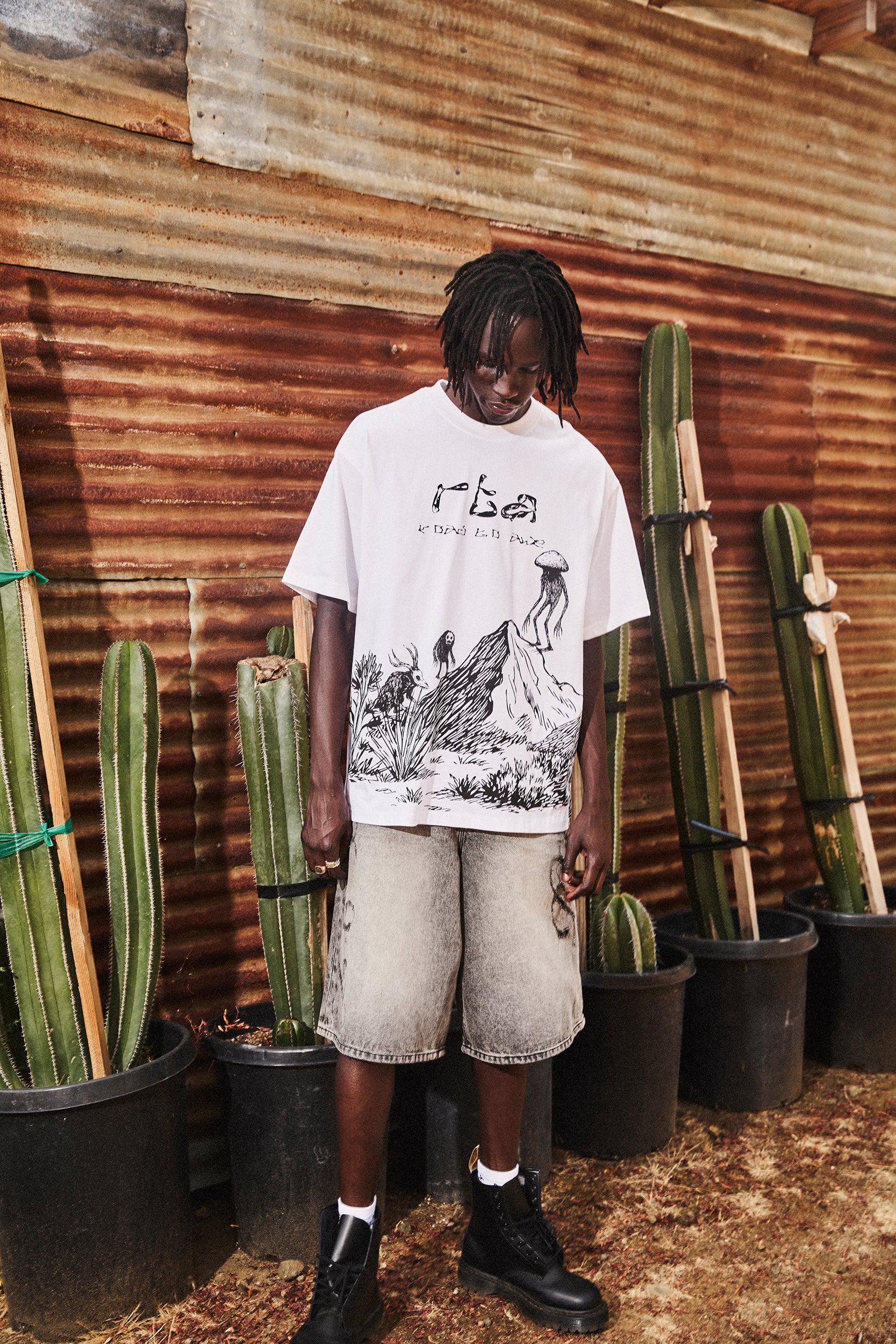 White Oversized Graphic Tee - Lifestyle Shot On Model with Denim Shorts, Creature Scenery Print | RTA