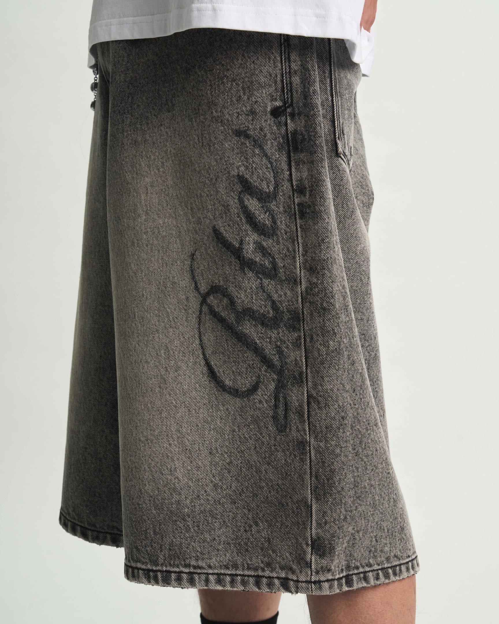 Stone Haze Laser Denim Short - On Model Left Side Graphic Script Close-Up | RTA