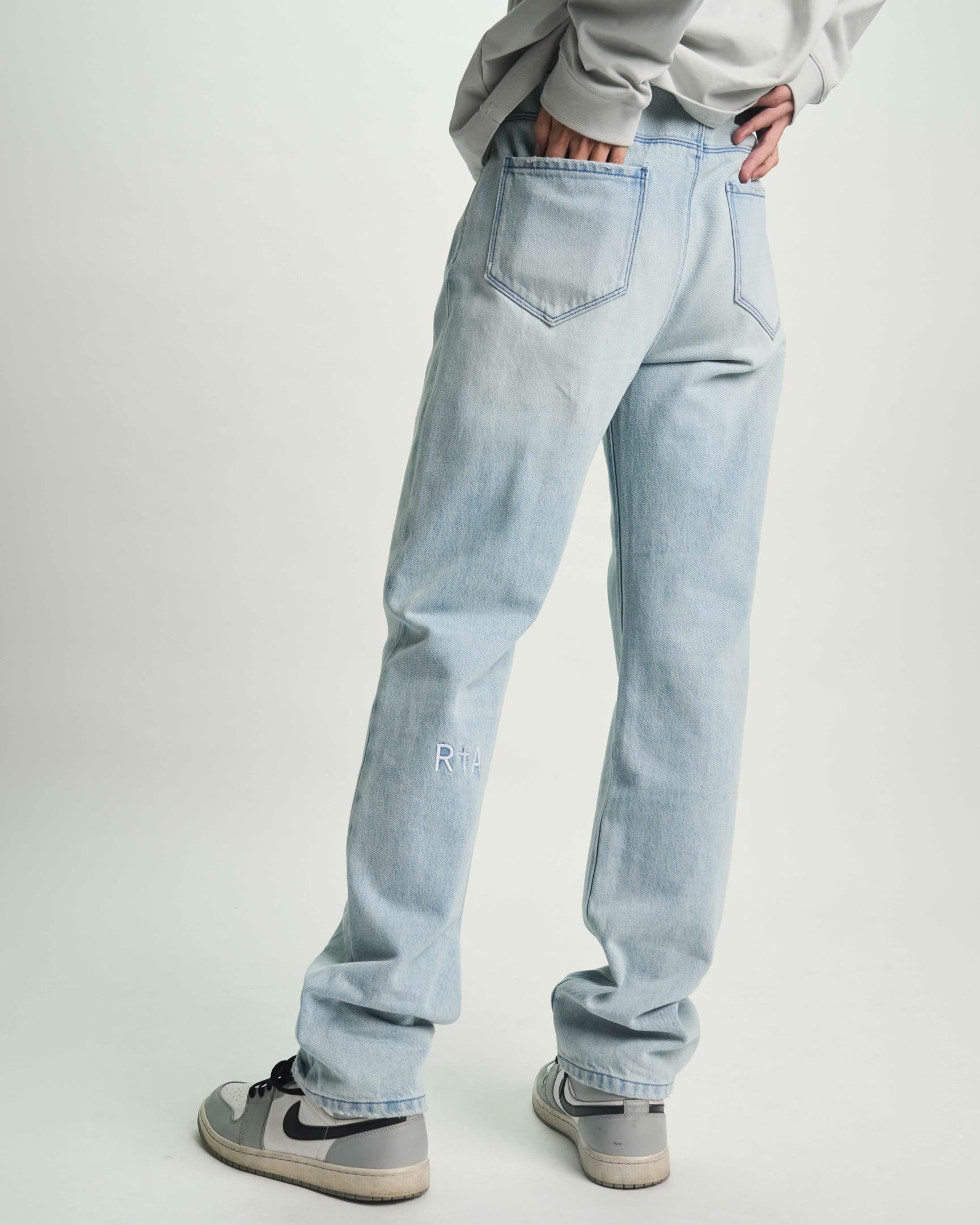 Light Blue Distressed Denim Slim Jean - On Model Back View with Logo Detail | RTA