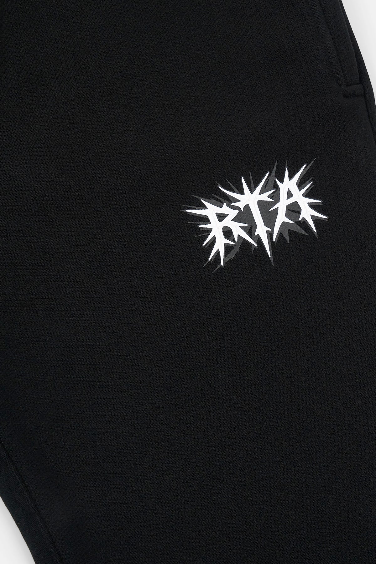 RTA Spike Logo Detail on Black Cotton Sweatpants - Close Up | RTA