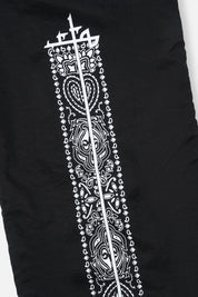 White Paisley Cross Graphics on Black Track Pants - Leg Detail | RtA